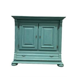 20th century continental painted cupboard, projecting cornice over two fielded panelled doors, each enclosing two slatted shelves, cushion fronted drawer to base, raised on compressed bun supports W157cm, H147cm, D56cm