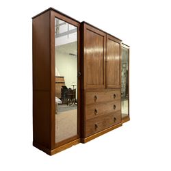 George III mahogany breakfront Gentleman's press, the central panelled doors enclosing five sliding trays over three cockbeaded drawers with lion mask handles, the flanking cupboards with full length mirror panels concealing hanging rails and drawers, raised on plinth base