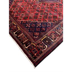 Iranian Joshagan crimson ground carpet, the central indigo lozenge containing further traditional geometric motifs, with matching spandrels, the field with all-over stylised plant decoration, the guarded border with alternating tree of life and other foliate motifs