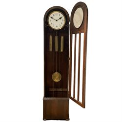 English - 1930's Westminster chime 8-day oak longcase clock, with a rounded top and full length three panel glazed door, visible pendulum and three brass-cased weights, circual painted dial with Arabic numerals and spade hands, three train chain driven movement with strike/silent facilty.