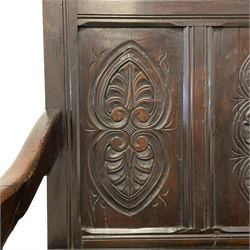 18th century carved oak high back settle, the two cresting horizontal back panels carved with concentric lozenges with central rosettes with extending foliage over four vertical panels carved with stylised anthemion leaves and acanthus and rose motifs, scrolled arm terminals over turned supports united by box stretcher