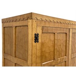 'Fishman' oak double wardrobe, adzed all-over, enclosed by two panelled doors, the interior fitted with hanging rails and shelf, carved with fish signature, by Derek Slater of Crayke