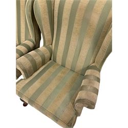 Parker Knoll - pair of wingback armchairs, upholstered in striped fabric, raised on cabriole supports 