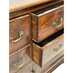 George III mahogany dresser base, rectangular top over four long drawers, two small drawers and two lower panelled cupboards, brass swan neck handles and circular handle plates, panelled sides, on ogee bracket feet