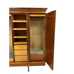 Victorian figured walnut Gentleman's press triple wardrobe, projecting cornice over three arched panelled doors with moulded frames, the central bevelled mirror door enclosing satin maple wood sliding trays over three drawers, the flanking doors concealing hanging rails and drawers, on skirted base