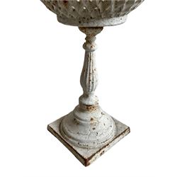 White painted cast iron flower basket stand, the latticework basket on turned and reeded stem, circular footed base