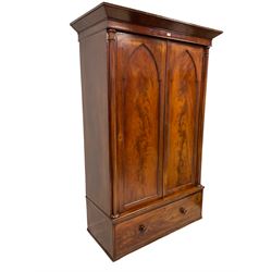 Early 19th century mahogany double wardrobe, projecting cornice over inset panelled doors enclosing hanging rail, column uprights on either side and single drawer to base
