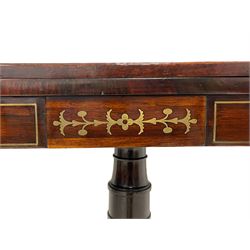 Regency rosewood and brass inlaid card table, the rectangular fold-over and swivelling top with rounded corners, inlaid with brass stringing and decorated with star motifs, baize lined interior playing surface, the frieze with a raised panel with brass stylise foliate decoration, turned column with gadroon carved base on a circular platform, quadruple splayed supports with cast brass hairy paw castors