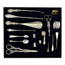Three silver thimbles, silver handled button hook and shoe horn, silver scissor action action sugar nips, silver tongs, silver handled tooth brush and other items 