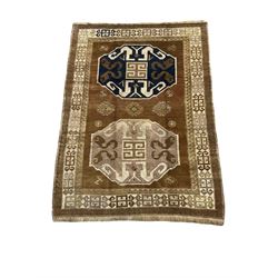 Turkish pale ground rug, decorated with two enlarged Gul motifs, triple band border with repeating design 
