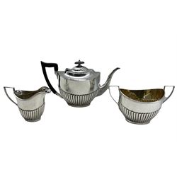Silver three piece tea set of oval design with half body reeded decoration, the teapot with ebonised handle and lift Sheffield 1918 Maker Viners Ltd 44oz gross