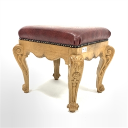 20th century carved oak footstool, with studded faux leather upholstered top  over shaped apron and leaf carved and scrolled supports, W39cm