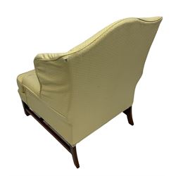 Georgian style wing back armchair, upholstered in lemon fabric, raised on square supports 