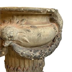 19th century two-piece terracotta garden planter, decorated with laurel leaf festoons held by mythical beast masks, fluted body moulded with leaves, on circular fluted footed base