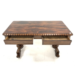 Victorian rosewood library table, the rectangular top with castellated edge and floral carved rounded corners over two frieze drawers, raised on two lobe carved end supports leading to platform base, floral scroll carved feet and brass castors, 128cm x 62cm, H74cm