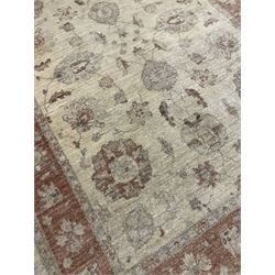 Beige ground rug with floral design and red border