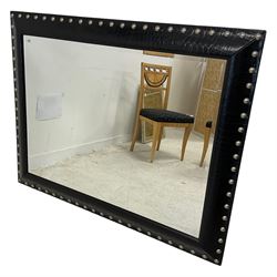 Large contemporary wall mirror, the rectangular frame in faux leather with rounded stud border, bevelled plate