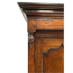 18th century oak housekeepers cupboard, projecting cornice over two panelled doors, fitted with three drawers over two cupboard doors enclosing single shelf, on stile feet 