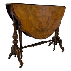 Late 19th century walnut Sutherland table, shaped bookmatched veneer drop-leaf top, raised on two vasiform turned column with splayed scrolled cabriole supports on brass castors, united by turned stretcher, the gate-leg supports turned and tapered terminating in brass castors