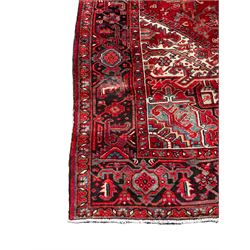 Persian Hamadan red ground rug, central floral lozenge medallion surrounded by stylised plant motifs and geometric patterns, repeating border with scrolling pattern and stylised flower heads