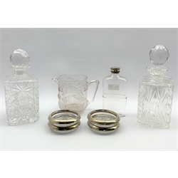 Two square cut glass spirit decanters, set of four Italian glass coasters with plated rims, moulded glass jug with swan and fish decoration H13cm and a glass flask