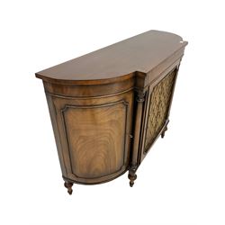 Regency style mahogany break bow front credenza sideboard, the top with rosewood cross band and boxwood string inlay, the central cupboard with brass grill and pleated silk cover enclosing shelf, flanked by two further cupboards, raised on turned supports W123cm