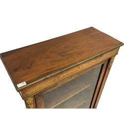 Late 19th century walnut pier cabinet, rectangular top with gilt metal edge in repeating foliate pattern, over satinwood inlaid foliate frieze, single glazed door enclosing two shelves, flanked by uprights with gilt metal mounts and stringing, on plinth base