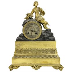 French early 19th century 8-day mantle clock, with a gilded figure of a  Turkish lady resting on a drum enclosed Parisian movement, on a broad decorated plinth resting on scroll feet, silvered dial with Roman numerals and steel moon hands, with a silk suspension and count wheel striking movement, striking the hours on a bell.