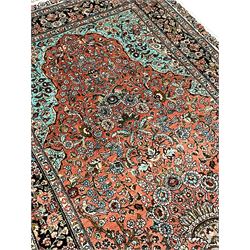 Hereke silk rug, pale pink ground field decorated with floral urn and bird motifs, decorated profusely trailing foliate and flower head motifs, the repeating guarded border decorated with stylised flower head motifs
