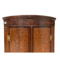 Early 19th century oak and mahogany banded bow-front corner cupboard, moulded cornice of figured frieze and two doors, the painted interior fitted with three shelves