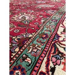 Persian rug from the Tabriz region, the red and floral field enclosed by green and ivory borders 346cm x 278cm