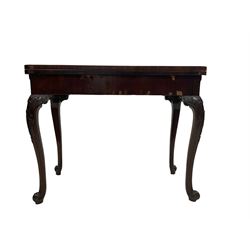 Early 19th century figured mahogany card table, the fold open top revealing circular baise inset, the double hinge extending base with oak sliding support, raised on cabriole supports with c-scroll and cartouche carved knees with extending foliate decoration