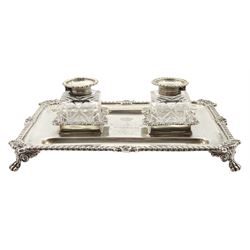 Edwardian silver inkstand of rectangular form with shell moulded and gadrooned edge fitted with two square glass inkwells with hinged silver covers and two pen trays on paw feet. Inscribed 'Presented to Viscount Helmsley on the Occasion of his Marriage.....1904' 23cm x 17cm Provenance: 2nd Earl of Feversham   