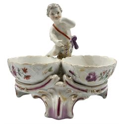 Pair of 19th century Berlin porcelain double salts, each modelled as a putto standing between two basket weave oval salts internally painted in polychrome enamels with exotic birds, and courting couples, raised upon three scroll supports, H12.5cm