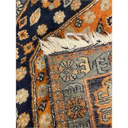 Small Persian rug or mat, extending rust ground field decorated with small stylised motifs, each corner with Gul motifs, trailing stylised flower heads
