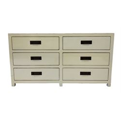Oriental design cream finish chest, fitted with six drawers with ebonised handles, panelled sides, raised on stile supports 