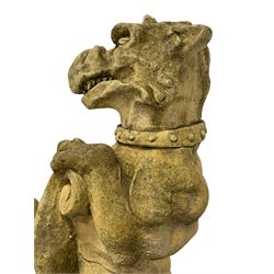 Pair of composite stone garden ornaments in the form of griffins or gargoyles holding cartouche shields