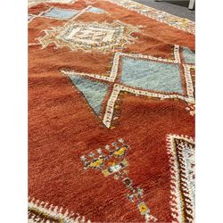 Ground rug with orange field and one central medallion, surrounded by a multi coloured border