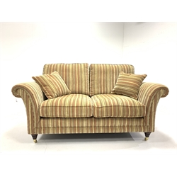 Parker Knoll Burghley two seat sofa upholstered in Baslow Stripe Gold fabric, raised on turned front supports with brass castors, W172cm