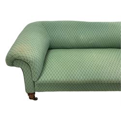 Late Victorian settee, walnut and hardwood framed, upholstered in green lozenge patterned fabric, on ring turned feet with brass and ceramic castors 