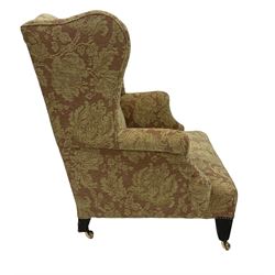 Georgian style armchair, upholstered in floral fabric, raised on square tapering supports, terminating in brass castors 