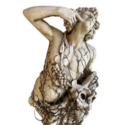 Mid-20th century Classical design cast stone figure of Bacchus or Dionysus, leaning against a tree stump semi-nude draped in grapes and trailing vine branches, holding a cup and wine vessel, the figure covered in trailing branches 