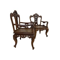 Pair Chinese carved hardwood armchairs, the cresting rail and centre splat pierced and carved with roses and scrolling decoration, the arm supports with stylised flowers in a geometric shape, panelled seat over carved scroll apron and cabriole supports