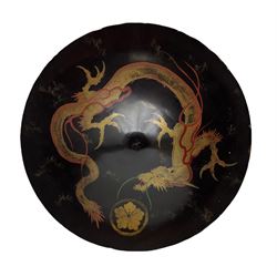 19th century Japanese black lacquer shield decorated with a mon and gilt dragon, the reverse with script D42cm