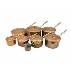 Set of seven graduated Italian copper saucepans and covers with brass handles, together with a set of four matching saucepans 