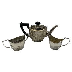 Edwardian bachelors silver three piece tea set with half body decoration, the teapot with ebonised handle and lift Chester 1903 Maker John Milward Banks 