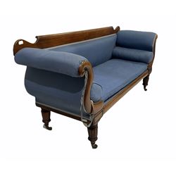 William IV mahogany scroll settee, the plain cresting rail over scroll shaped arm supports, raised on lobe carved front supports terminating at brass cups and castors, upholstered in blue fabric with squab and baluster cushions