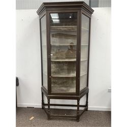 Large early 20th century oak shop display cabinet, with glazed canted sides and door enclosing a crushed velvet lined interior with four shelves, raised on stand with turned supports and stretchers W120cm, H233cm, D44cm