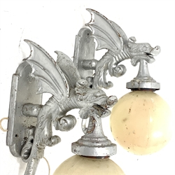 Pair of modern cast metal wall lights, each modelled as a winged dragon with globular shades, H68cm approx