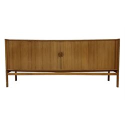 Mid 20th century teak sideboard, rectangular top over tambour sliding front enclosing four shelves and four sliding trays